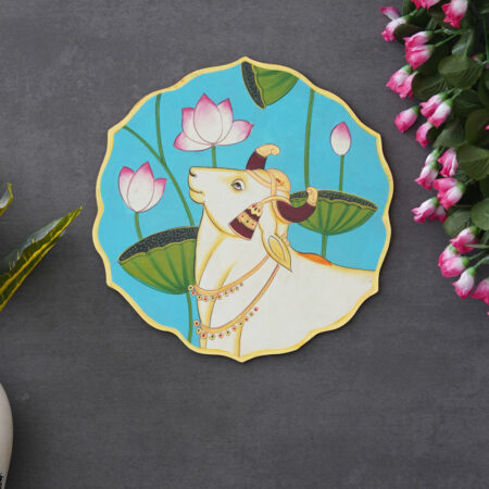 Elegant Pichwai-style cow and lotus painting on blue background — symbol of purity and devotion in Indian art.