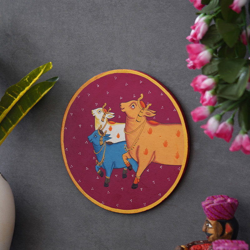 Colorful Pichwai painting of three sacred cows — traditional Indian wall art symbolizing harmony and divinity.
