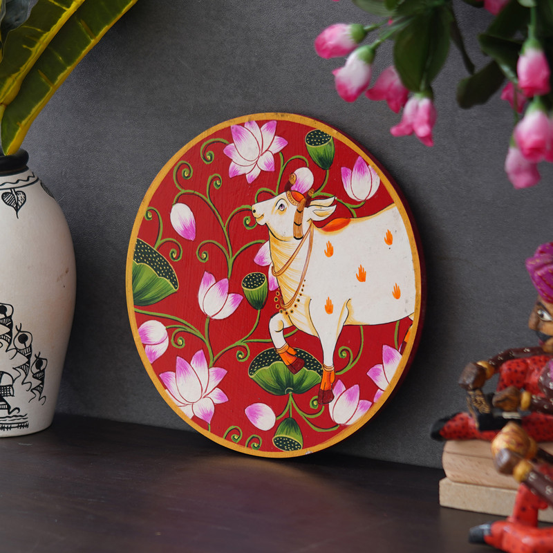 Handcrafted Pichwai wall art of a white cow amid blooming pink lotuses — ideal for ethnic home decor.