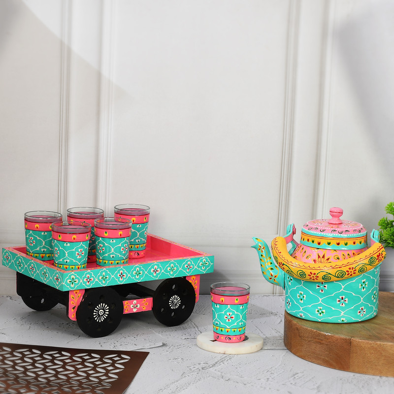 Vibrant pink and turquoise Indian art tea set with floral kettle and decorative glass holder