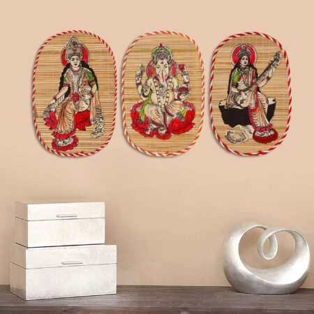 Artisan-crafted bamboo wall hanging set depicting Lakshmi, Ganesha, and Saraswati, cultural Indian art for Diwali interiors