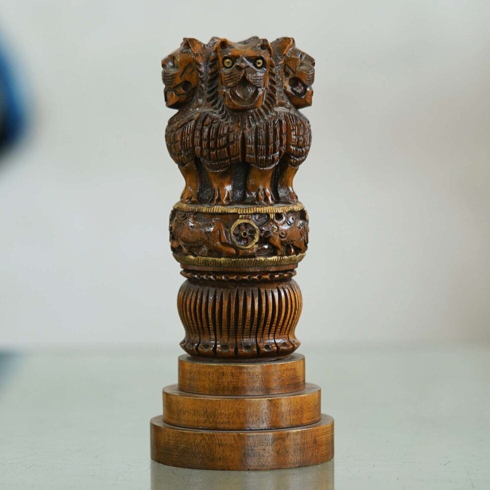 Polished wooden Ashoka Stambh sculpture showcasing intricate lion and chakra carvings, handmade Indian art piece.